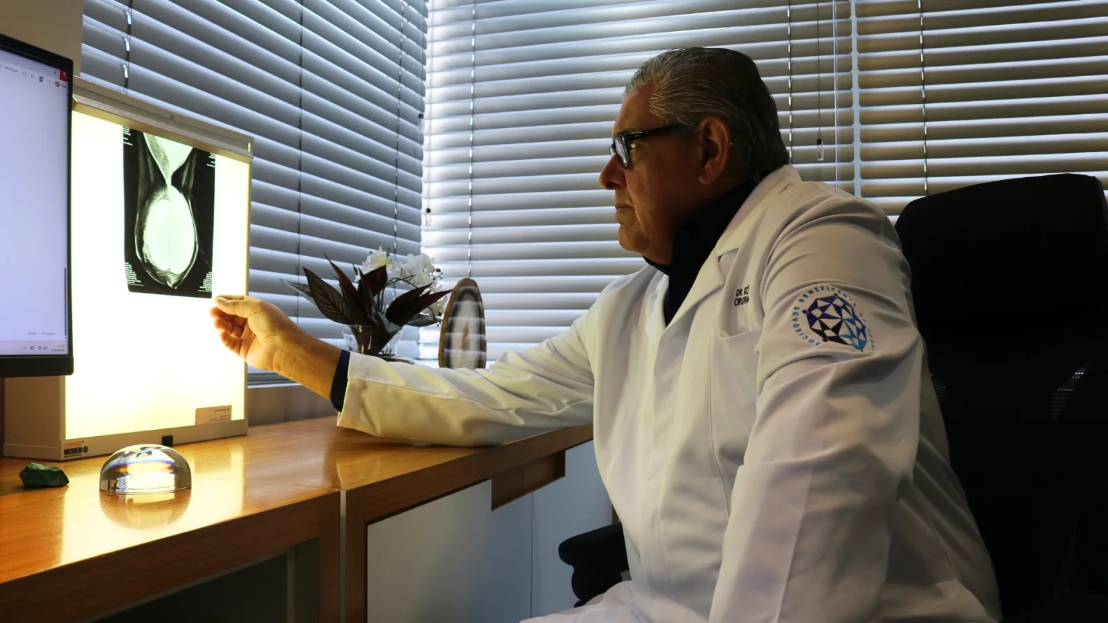 Dr. Eduardo Daud analisando exame de imagem no consultório